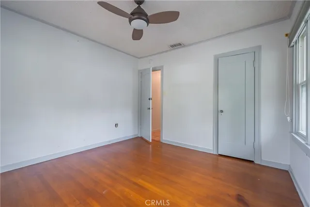 an empty room with a ceiling fan and carpet