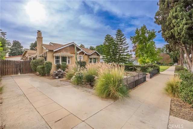 a front view of a house with a yard and potted plants
