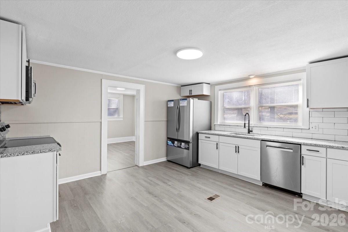 2217 Old Shelby Road Hickory, NC 28602 - Photo 11 of 20 a kitchen with a sink a refrigerator and wooden floor