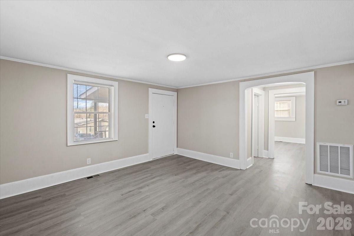 2217 Old Shelby Road Hickory, NC 28602 - Photo 4 of 20 a view of an empty room with wooden floor and a window