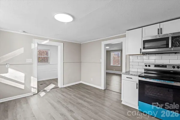 a kitchen with granite countertop a stove and a microwave