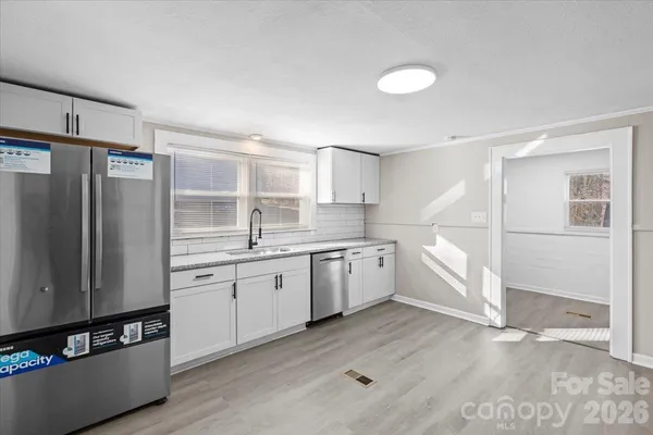 a kitchen with granite countertop a refrigerator and a sink