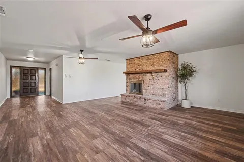 a view of a livingroom with a hardwood floor and ceiling fan