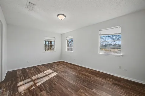 a view of a bedroom with wooden floor and window