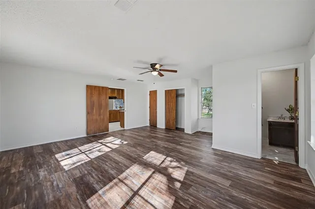 a view of a livingroom with wooden floor and a ceiling fan