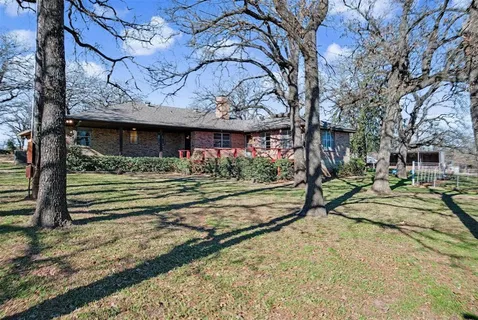 a view of a house with large trees
