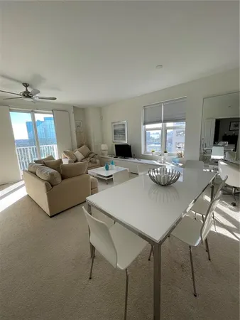 a living room with furniture a flat screen tv and a window