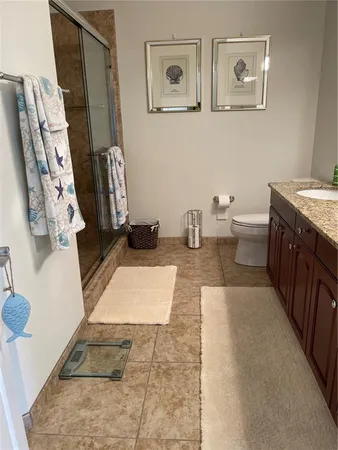 a bathroom with a granite countertop sink a toilet and a tub
