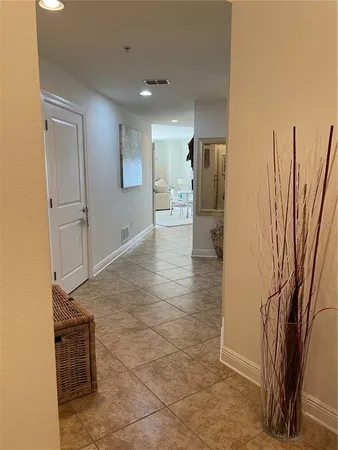 a view of a refrigerator in kitchen and an empty room