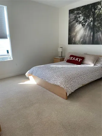 a bedroom with a bed and painting on the wall