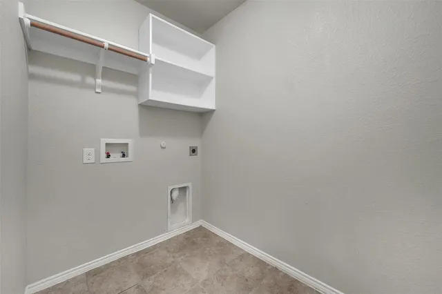 an empty room with fireplace wooden floor windows and a ceiling fan