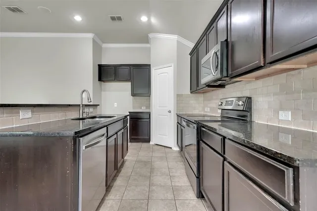 a kitchen with stainless steel appliances granite countertop a stove and a sink