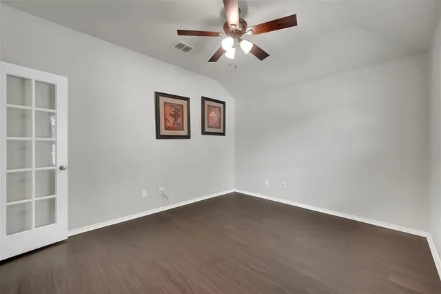 an empty room with a window and ceiling fan
