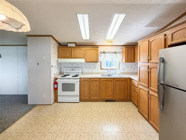 a kitchen with granite countertop a sink stove and refrigerator