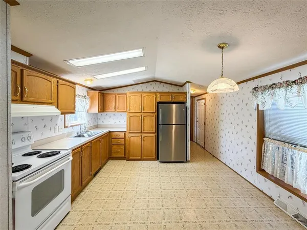 a kitchen with a refrigerator a sink and a cabinets
