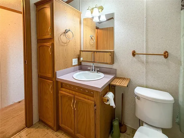 a bathroom with a granite countertop sink toilet and shower