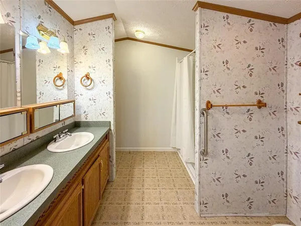 a bathroom with a sink a granite counter and a shower