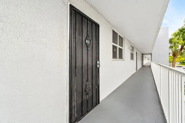 a view of a hallway with wooden floor and stairs
