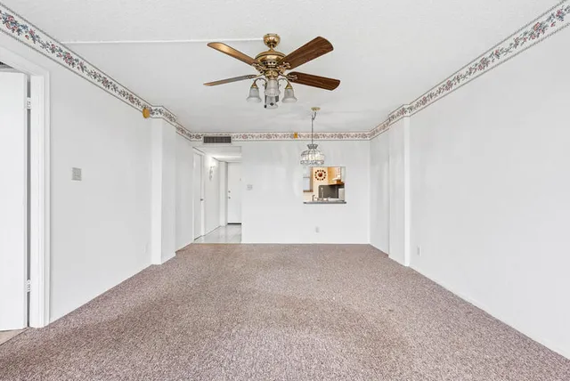 a view of a livingroom with a ceiling fan and window
