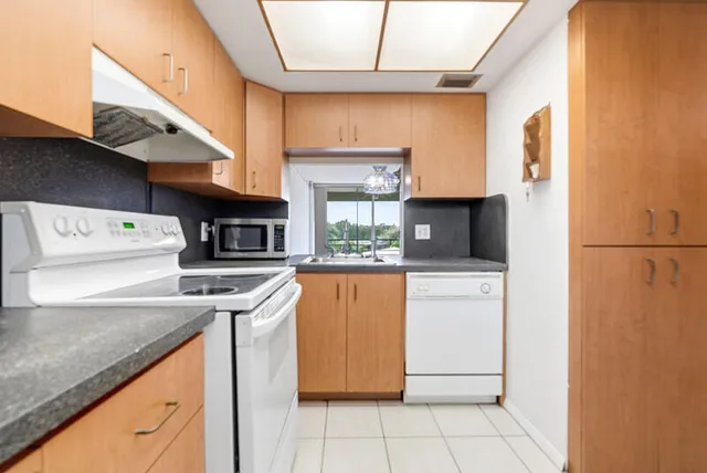 a kitchen with a sink a stove top oven and cabinets