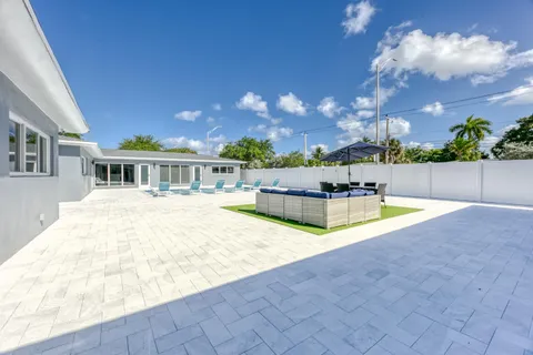 a view of house with swimming pool and sitting area
