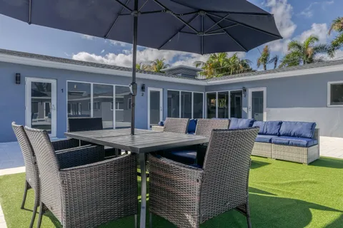 a view of a patio with couches chairs under an umbrella