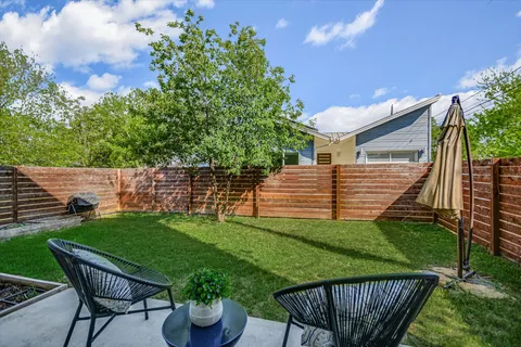 a backyard of a house with table and chairs