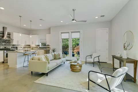 a living room with furniture kitchen and a large window