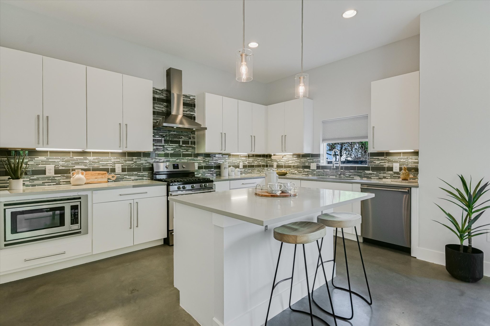 1131 Mason Avenue, Unit A Austin, TX 78721 - Photo 8 of 24 a kitchen with kitchen island granite countertop a sink a stove a refrigerator and white cabinets with wooden floor