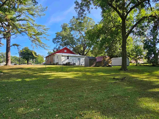 a front view of house with garden and trees