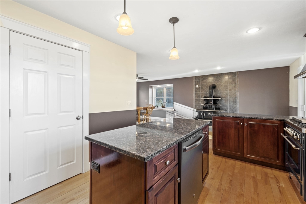 358 Reed Road Mason, NH 03048 - Photo 9 of 42 a kitchen with stainless steel appliances granite countertop a sink a stove and a wooden floors