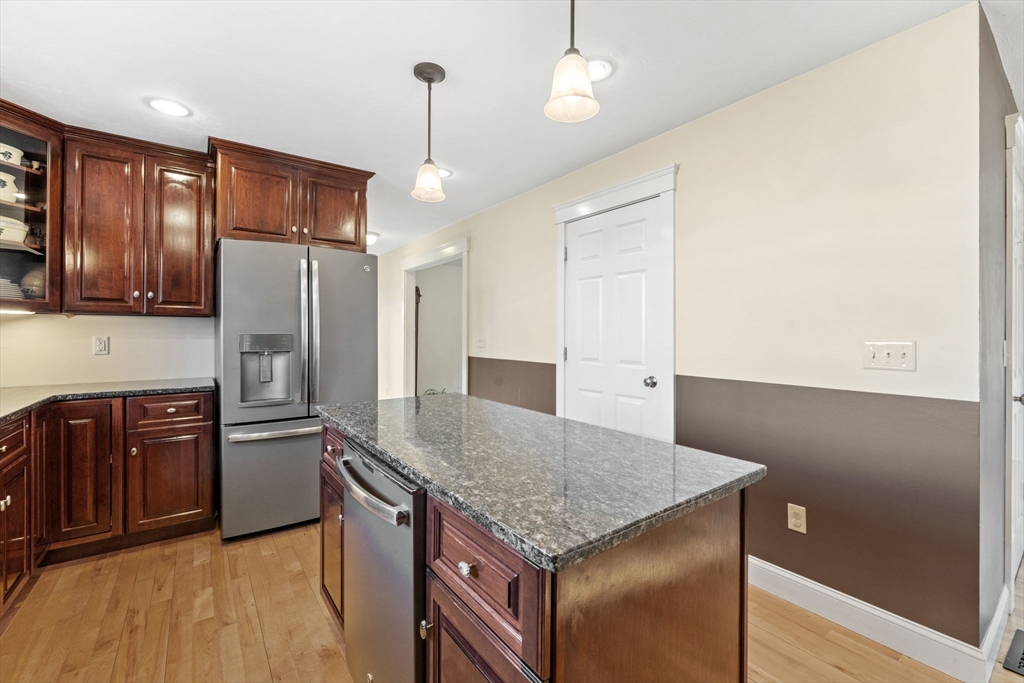 358 Reed Road Mason, NH 03048 - Photo 10 of 42 a kitchen with a refrigerator a sink and wooden cabinets