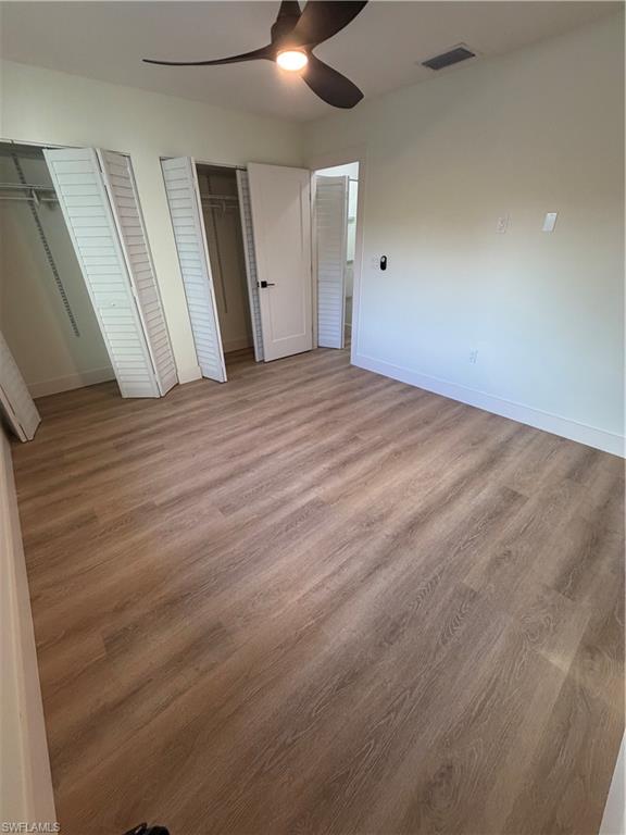 3619 Poplar Way, Unit B Naples, FL 34112 - Photo 12 of 17 an empty room with wooden floor and windows