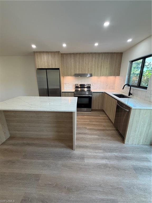 3619 Poplar Way, Unit B Naples, FL 34112 - Photo 13 of 17 a large kitchen with stainless steel appliances kitchen island a large counter top and a stove