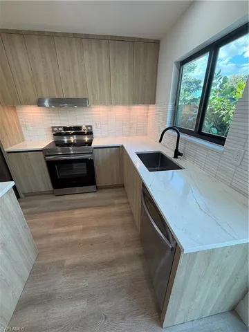 a kitchen with granite countertop a stove sink and cabinets