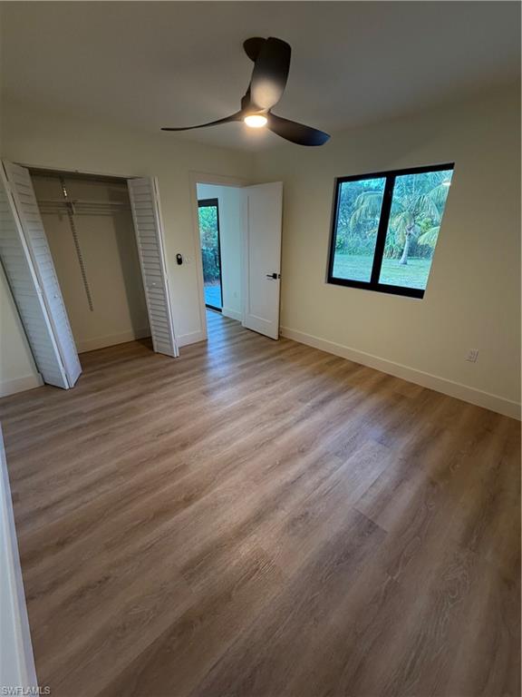 3619 Poplar Way, Unit B Naples, FL 34112 - Photo 5 of 17 an empty room with wooden floor and windows