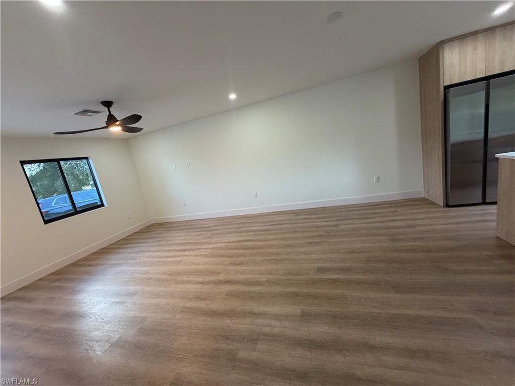 3619 Poplar Way, Unit B Naples, FL 34112 - Photo 7 of 17 wooden floor in an empty room with a window