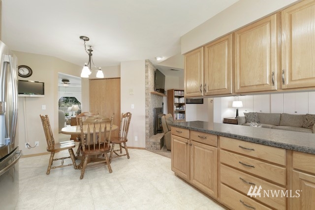 8970 Postma Road Moxee, WA 98936 - Photo 19 of 31 a kitchen with stainless steel appliances kitchen island granite countertop a table chairs sink and cabinets