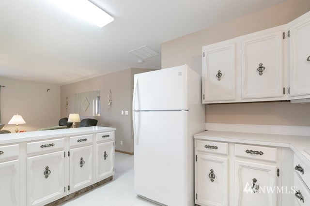 8970 Postma Road Moxee, WA 98936 - Photo 27 of 31 a kitchen with white cabinets and refrigerator