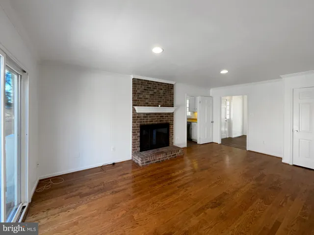 a view of an empty room with a fireplace and a window