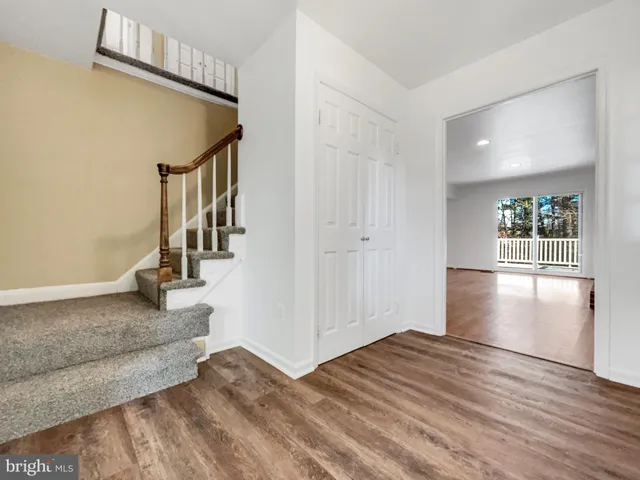 a view of a hallway view with wooden floor and staircase