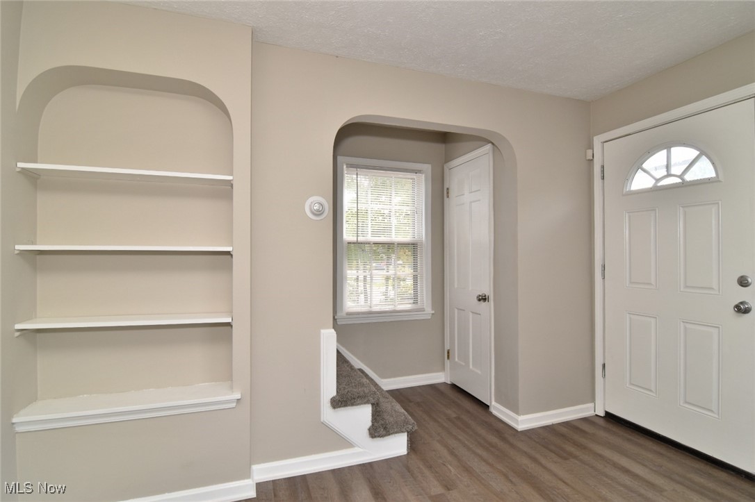 1443 Churchill Road Lyndhurst, OH 44124 - Photo 2 of 39 Foyer entrance with dark wood finished floors, a textured ceiling, arched walkways, and stairs