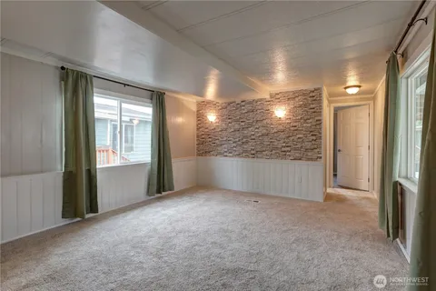 a view of empty room with windows and bathroom view