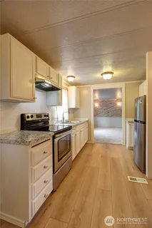a large kitchen with a refrigerator a stove top oven a sink dishwasher and wooden cabinets