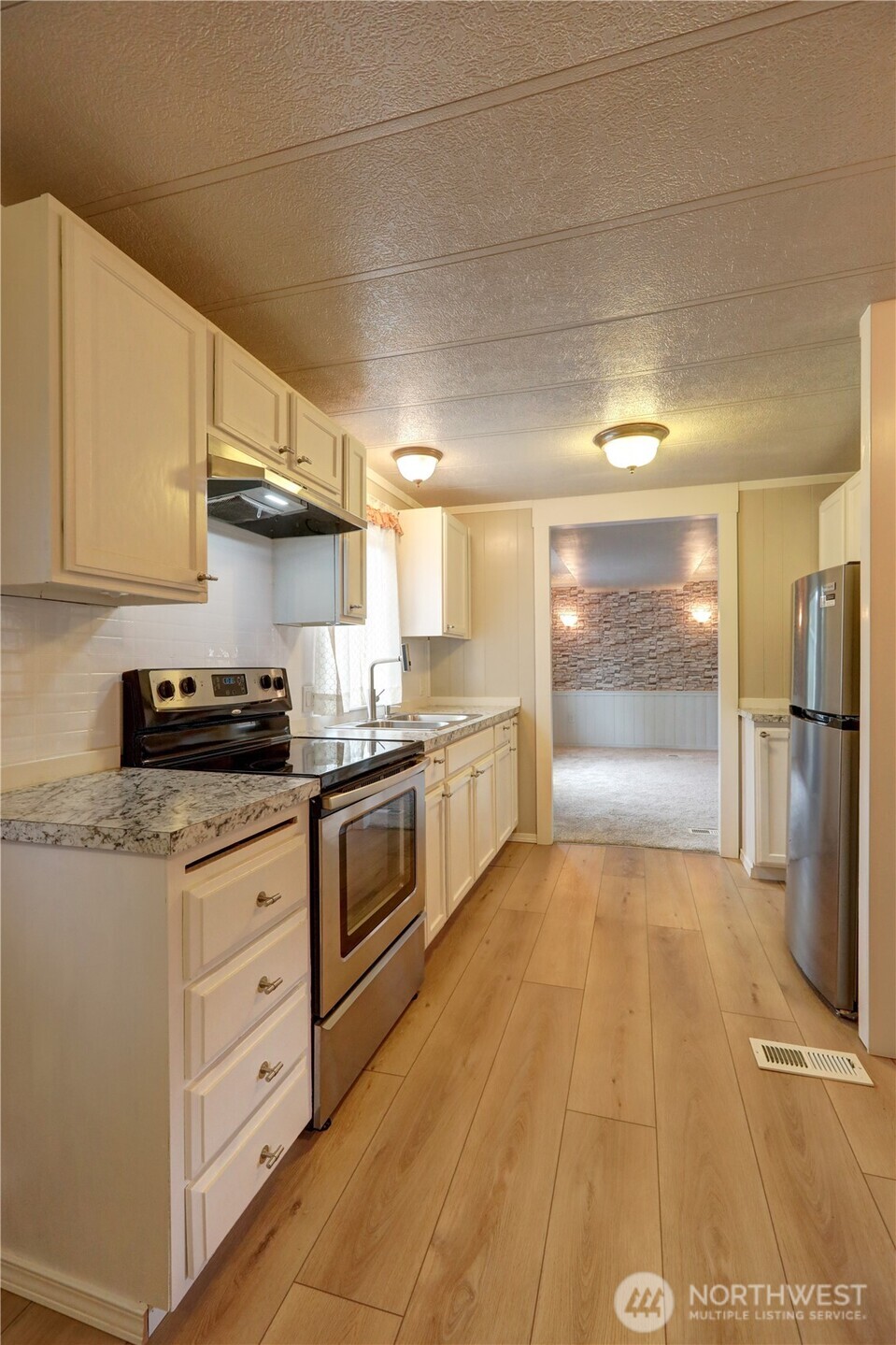 32501 Northeast 50th Street, Unit 6 Carnation, WA 98014 - Photo 6 of 13 a kitchen with granite countertop a refrigerator and a stove top oven