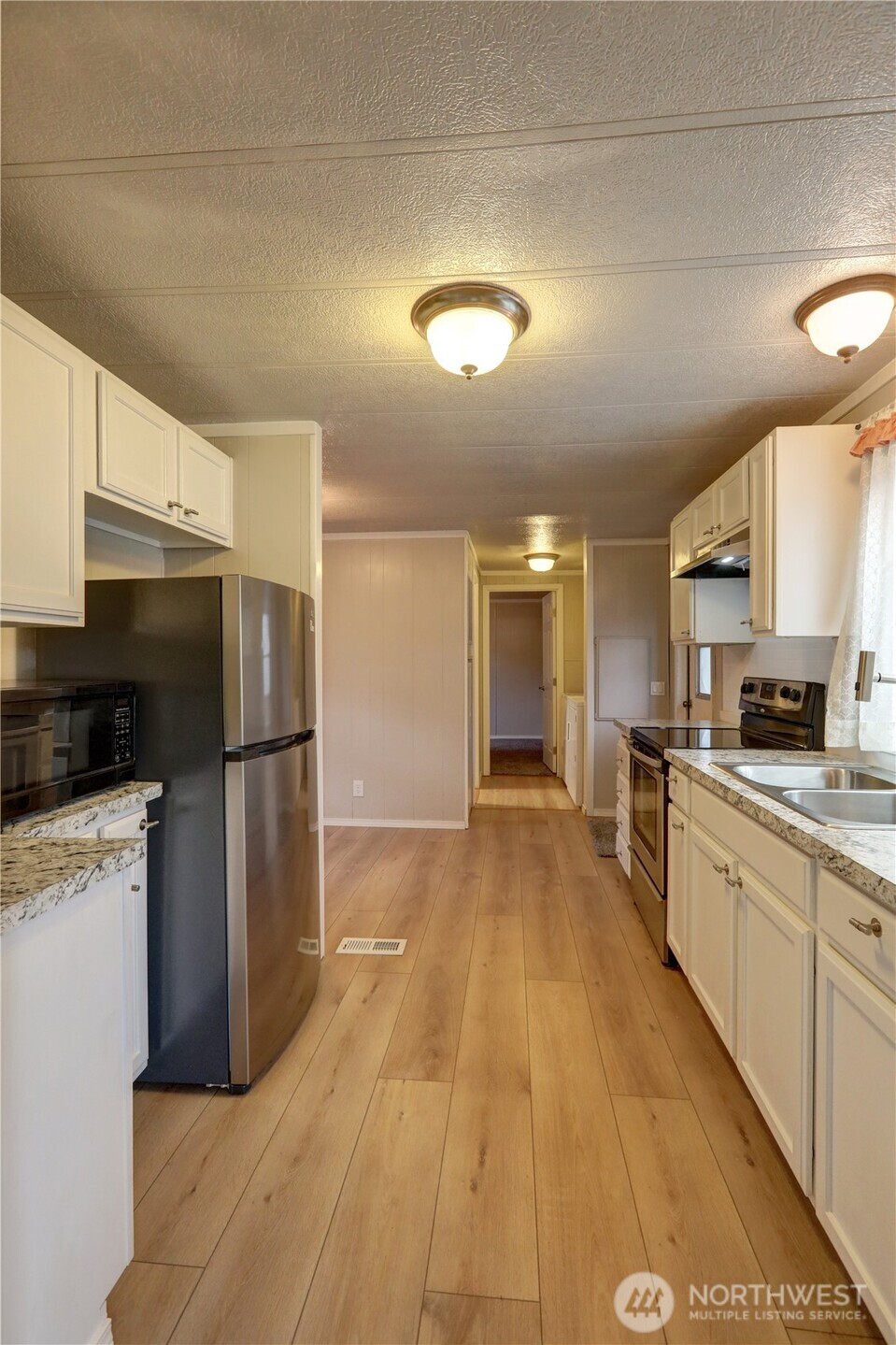 32501 Northeast 50th Street, Unit 6 Carnation, WA 98014 - Photo 7 of 13 a large kitchen with a refrigerator a stove top oven a sink dishwasher and wooden cabinets