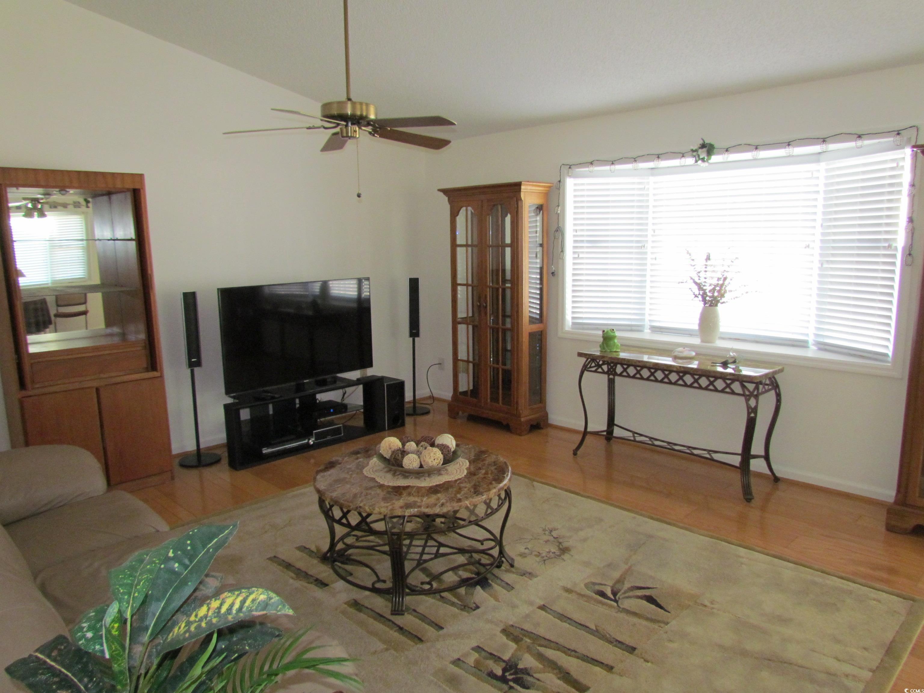 100 Inverness Court Myrtle Beach, SC 29588 - Photo 8 of 22 Living area featuring wood finished floors, vaulted ceiling, and a ceiling fan