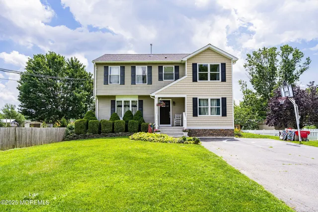 a front view of a house with a yard and trees