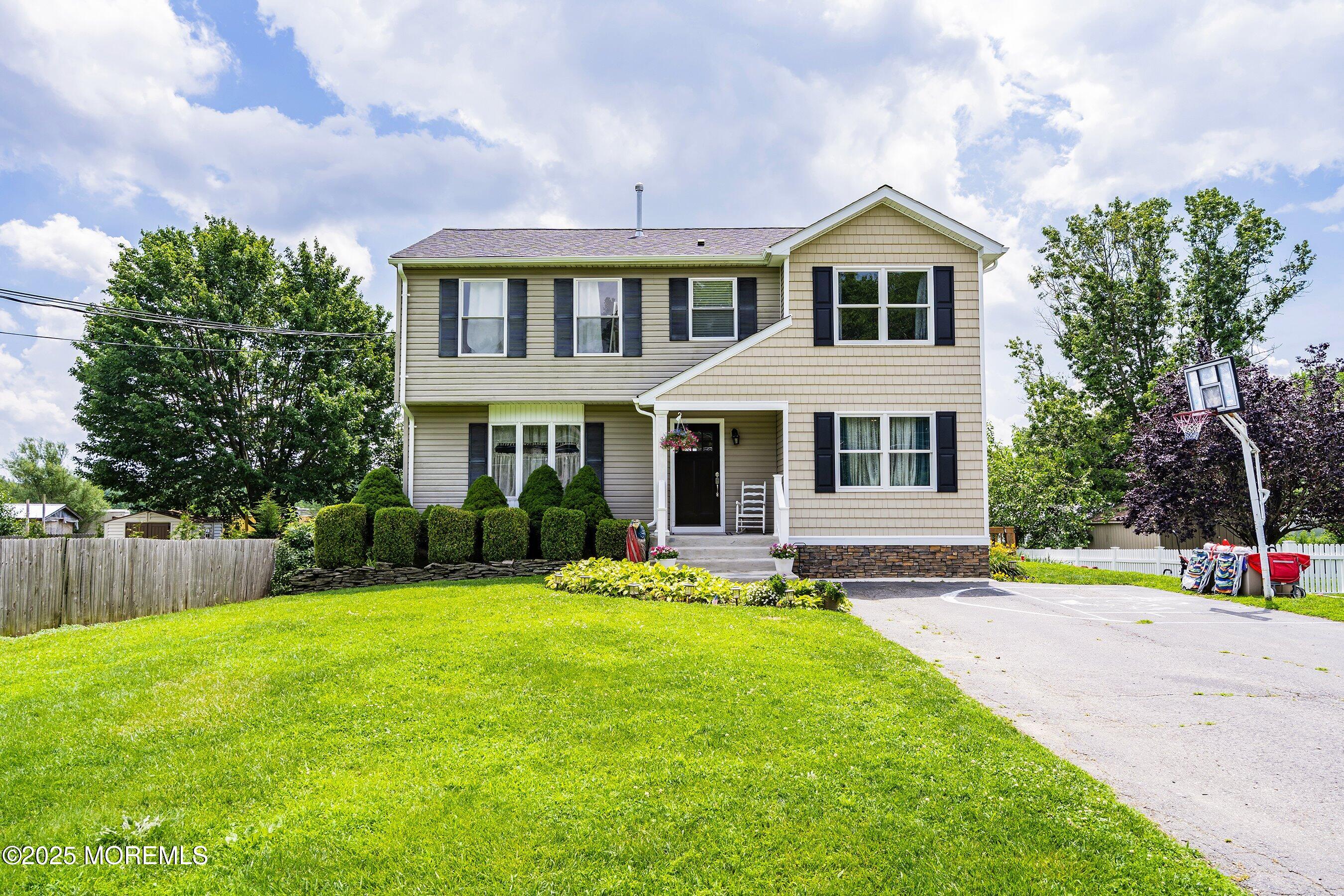 a front view of a house with a yard and trees