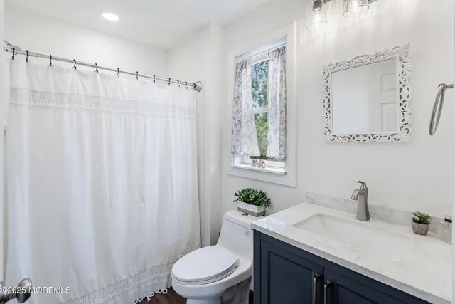 a bathroom with a sink a toilet and shower curtain